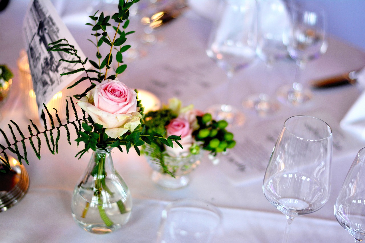 Das Bild zeigt einen festlich gedeckten Tisch mit einer Rose.